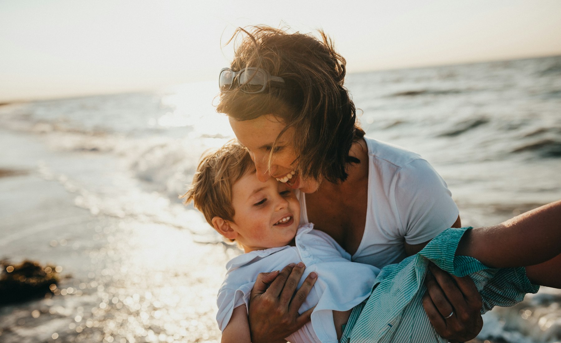 A parent holding their child close at golden hour